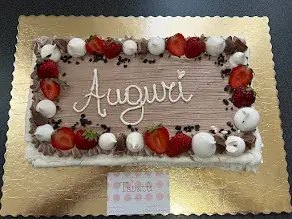 Torta rettangolare decorata con panna e frutti rossi realizzata da Tabatù